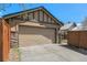 Attached garage with a paved driveway and partial stone facade, providing convenient parking at 529 Uinta Way, Denver, CO 80230