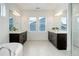 Bright bathroom with double sink vanity, modern mirrors, and a large soaker tub at 39405 Stockton Cir, Elizabeth, CO 80107
