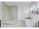 Modern bathroom featuring a glass-enclosed shower, soaker tub, and bright natural light at 39405 Stockton Cir, Elizabeth, CO 80107
