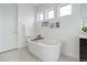 Bathroom featuring a soaker tub with a wooden tray and bright natural light from three windows at 39405 Stockton Cir, Elizabeth, CO 80107