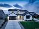 Modern farmhouse exterior with black trim, three-car garage, and manicured lawn at twilight at 39405 Stockton Cir, Elizabeth, CO 80107
