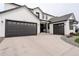 Modern home showcasing a three-car garage and black trim against white siding, creating a striking and inviting curb appeal at 39405 Stockton Cir, Elizabeth, CO 80107