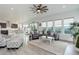 Open-concept living room with gray sofa, kitchen, dining area, and bright natural light at 39405 Stockton Cir, Elizabeth, CO 80107