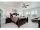 Spacious main bedroom featuring a dark wood bed frame, ceiling fan, and bright natural light at 39405 Stockton Cir, Elizabeth, CO 80107