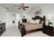Bright main bedroom with a dark wood bed frame, ceiling fan, and ensuite bathroom access at 39405 Stockton Cir, Elizabeth, CO 80107