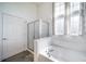 Bright bathroom featuring tile floors, a glass shower door, and a large garden tub at 3000 E 112Th Ave # 56, Northglenn, CO 80233