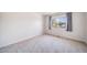 Spacious bedroom with neutral carpet and a window showcasing the outside greenery at 3000 E 112Th Ave # 56, Northglenn, CO 80233