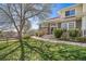 Charming two-story home with a stone facade, lush lawn, and mature landscaping with a large shade tree at 3000 E 112Th Ave # 56, Northglenn, CO 80233