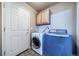 Functional laundry room with modern washer, dryer, and convenient overhead cabinet storage at 3000 E 112Th Ave # 56, Northglenn, CO 80233