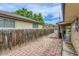 Backyard featuring brick patio, wooden fence, and partial home view, providing privacy and charm at 7995 Robin Ln, Denver, CO 80221