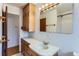 Bathroom featuring a vanity with cabinets and drawers, a sink, and a well-lit mirror at 7995 Robin Ln, Denver, CO 80221