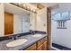 Bathroom featuring double sinks, large mirror, and enclosed shower in the updated space at 7995 Robin Ln, Denver, CO 80221