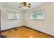 Bedroom featuring hardwood floors, ceiling fan and ample natural light from two windows at 7995 Robin Ln, Denver, CO 80221