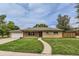 Traditional brick home with a curved walkway and attached garage at 7995 Robin Ln, Denver, CO 80221