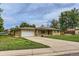 Lovely brick home with a spacious driveway and a well manicured lawn at 7995 Robin Ln, Denver, CO 80221