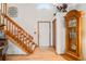 Bright foyer with hardwood floors, a staircase with plush carpeting, and an elegant grandfather clock at 5689 S Youngfield Way, Littleton, CO 80127