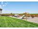 Large backyard with a play structure, greenhouse, garden beds and ample lawn space at 4863 Quail Ct, Frederick, CO 80504