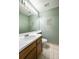 Half bath features tiled floors, wood cabinets, and a decorative mirror at 4863 Quail Ct, Frederick, CO 80504
