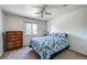 Bedroom featuring a ceiling fan, window, dresser, and a comfortable bed with patterned bedding at 4863 Quail Ct, Frederick, CO 80504