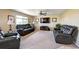 Carpeted living room featuring dual sofas, a ceiling fan, and a large window at 4863 Quail Ct, Frederick, CO 80504