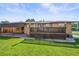 Large backyard with a wooden deck, green lawn, and convenient covered parking area at 5703 Field St, Arvada, CO 80002