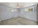 Empty bedroom with gray carpet, two windows with white shutters, and ceiling fan at 5703 Field St, Arvada, CO 80002