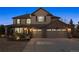 Charming two-story home with a three-car garage, brick accents, and well-manicured landscaping at dusk at 1302 Milbury St, Castle Rock, CO 80104