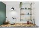 Wet bar area featuring open shelving with glass shelves, a designer backsplash, and a small prep sink at 1302 Milbury St, Castle Rock, CO 80104