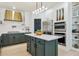 Gourmet kitchen features stainless steel appliances, a center island, and custom green cabinetry at 1302 Milbury St, Castle Rock, CO 80104