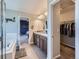 Bright bathroom with double sink vanity, a bathtub, and access to the walk-in closet at 30 Sun Up Ct, Erie, CO 80516