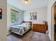 Bright bedroom with a wooden bed frame, dresser, and window offering natural light at 30 Sun Up Ct, Erie, CO 80516
