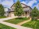 Charming two-story home featuring a well-manicured lawn, stone accents, and an inviting front porch at 30 Sun Up Ct, Erie, CO 80516