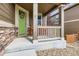 Charming front porch featuring a bright green door, stone accents, and a cozy seating area at 30 Sun Up Ct, Erie, CO 80516