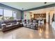 Open-concept living room with hardwood floors and a large sectional sofa, open to the kitchen at 30 Sun Up Ct, Erie, CO 80516