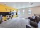 Spacious living room with plush carpeting, three large windows, and comfortable seating area at 30 Sun Up Ct, Erie, CO 80516
