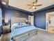 Stylish primary bedroom with a large bed, blue color scheme, and ceiling fan at 30 Sun Up Ct, Erie, CO 80516