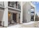 Close-up of a modern townhome showcasing a covered porch with seating, adding charm and functionality to the entrance at 4260 E Warren Ave # 5, Denver, CO 80222