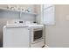 Functional laundry room with modern washer and dryer and upper shelf storage at 4260 E Warren Ave # 5, Denver, CO 80222