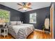 Charming bedroom features hardwood floors, stylish ceiling fan, and natural light from two windows at 1540 Filbert Ct, Denver, CO 80220