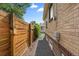 A side view showing a brick house and a wooden fence at 1540 Filbert Ct, Denver, CO 80220