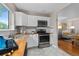 Bright kitchen boasts white cabinets, wood countertops, and stainless steel appliances, with an open view into the living area at 1540 Filbert Ct, Denver, CO 80220