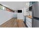 View of kitchen and living space, including stainless fridge and modern counters at 1540 Filbert Ct, Denver, CO 80220