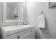 Neat, neutral bathroom with white cabinets, sink, mirror, and towel rack at 4633 S Crystal Way # E189, Aurora, CO 80015