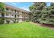 Well-maintained building with a manicured lawn and mature trees, creating a welcoming atmosphere at 5770 E Warren Ave # 206, Denver, CO 80222