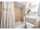 Cozy bathroom featuring a bathtub with shower, neutral tiling, and decorative shelving at 2 Adams St # 905, Denver, CO 80206