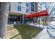 Building entrance featuring a red awning at 2 Adams St, landscaping, and seating area at 2 Adams St # 905, Denver, CO 80206