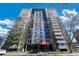 Modern high-rise condo building with balconies against a vibrant blue sky and mature trees at 2 Adams St # 905, Denver, CO 80206