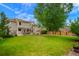 Large backyard with well-maintained lawn, patio area, and mature trees for privacy at 2061 Chesapeake Pl, Highlands Ranch, CO 80126