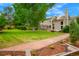 Expansive backyard featuring a lush lawn, patio, and charming landscaping with a stone walkway at 2061 Chesapeake Pl, Highlands Ranch, CO 80126