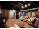 Spacious basement boasting an entertainment area with a cozy sectional and staircase access at 2061 Chesapeake Pl, Highlands Ranch, CO 80126